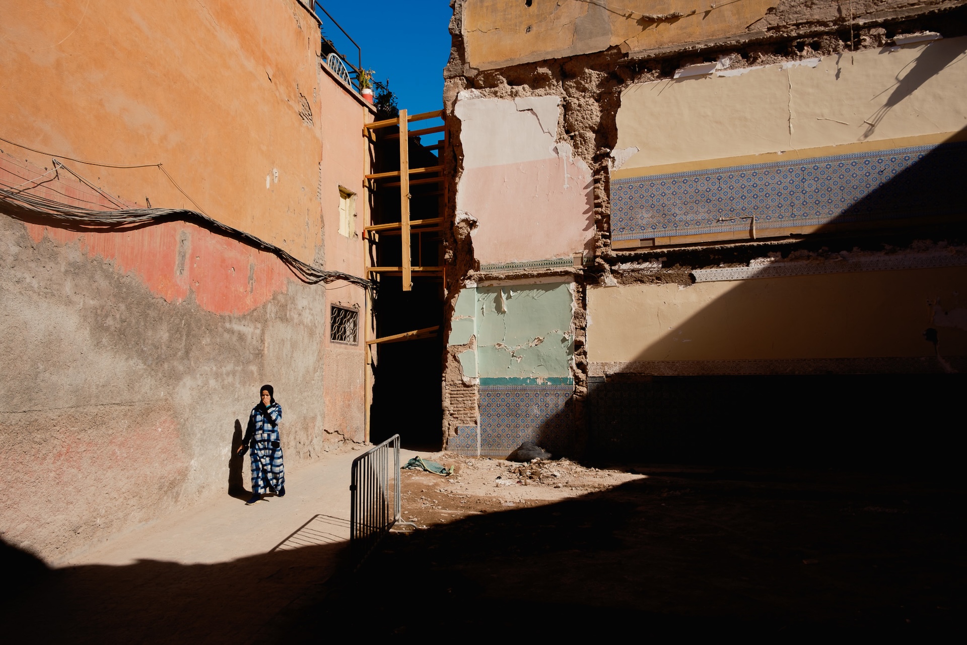 A waman un the street of Marrakech and the sign of the recent heartquake